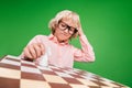 Photo of young puzzled minded boy look board think move chess horse isolated on green color background