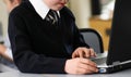 Young schoolboy using laptop at desk