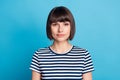 Photo of young serious calm woman wear striped t-shirt charming casual, style isolated on blue color background