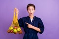 Photo of young shocked amazed beautiful girl advertise recommend recycle net bag isolated on purple color background