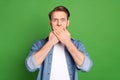 Photo of young shocked amazed surprised man cover mouth with hands oops guilty isolated on green color background