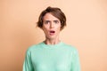 Photo of young shocked speechless amazed surprised girl o-pen mouth look camera isolated on beige color background