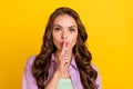 Photo of young silent speechless young woman hold finger face secret tell mute isolated on yellow color background