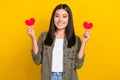 Photo of young smiling vietnamese girl wear khaki trendy shirt brunette hair hold red love symbols valentine day