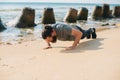 Photo of young sport man making push ups on the beach near sea Royalty Free Stock Photo