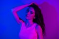 Photo of young stunning beautiful gorgeous girl with long hair posing on camera sensual shot on neon blue color