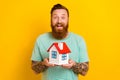 Photo of young surprised man red hair beard wear green t-shirt hold real estate relocation promo realtor agency isolated