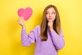 Photo of young suspicious girl touch chin minded looking ponder hold pink paper heart symbol unsure about boyfriend