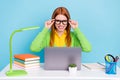 Photo of young sweet ginger lady work from home hands spectacles wear green sweater isolated on blue color background