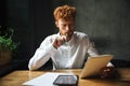 Photo of young thinking readhead bearded man, holding notebook a Royalty Free Stock Photo