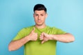 Photo of young unhappy man make fingers thumb up down choose uncertain doubt isolated on blue color background