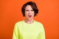 Photo of young unhappy sad displeased angry woman bad mood grimace isolated on orange color background