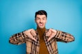 Photo of young unhappy upset annoyed disgusted man showing thumb-down isolated on blue color background