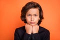 Photo of young unhappy upset sad boy hold hands chin face offended bad mood  on orange color background Royalty Free Stock Photo