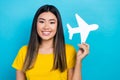 Photo of young vietnamese girl wear yellow t-shirt hold paper origami airplane flying abroad lowcost ad isolated on blue Royalty Free Stock Photo