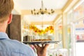 Young waiter serving coffee and cookies at restaurant Royalty Free Stock Photo