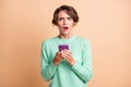 Photo of young woman amazed shocked sad dislike use smartphone isolated over pastel color background Royalty Free Stock Photo
