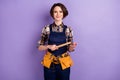 Photo of young woman builder craftsman hold hammer tools repair restoration isolated over violet color background