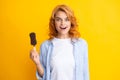 Photo of young woman eats delicious ice cream, enjoys frozen dessert, dressed in casual clothes, isolated on yellow Royalty Free Stock Photo