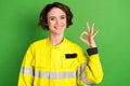 Photo of young woman firefighter happy positive smile show okay sign alright perfect great isolated over green color