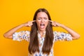 Photo of young woman irritated annoyed close ears forefingers angry yell isolated over yellow color background Royalty Free Stock Photo