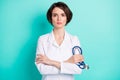 Photo of young woman serious crossed hands hold stethoscope therapist clinic illness isolated over teal color background