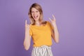 Photo of young woman showing rock sign and screaming having fun isolated over violet color background Royalty Free Stock Photo