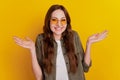 Photo of young woman shrug shoulders isolated over yellow background