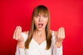 Photo of young woman unhappy negative angry mad accuse blame fail trouble isolated over red color background