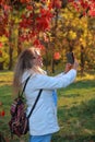 A young woman photographs nature with a mobile phone Royalty Free Stock Photo