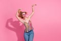 Photo of youth fancy crazy girl wearing denim jeans with stylish bright singlet dancing hands up rhythm  on pink Royalty Free Stock Photo