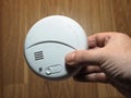 Photoelectric smoke detector. Hand with smoke detector