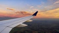 Photograph of an airplane with its commercial wide-body wing ascending to the height of the cruising clouds. Royalty Free Stock Photo