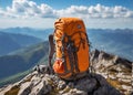 Photograph of a backpack left on a high mountain peak with a panoramic view of the mountains.