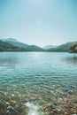 photograph of the beautiful lake with clear water, surrounded hills and mountains Royalty Free Stock Photo