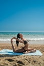 Photograph of a beautiful woman doing yoga exercise on a beach o