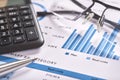 Photograph of blue financial and planning chart with black calculator, glasses and silver pen Royalty Free Stock Photo