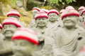 Photograph of blurred Buddha statues with red and white caps