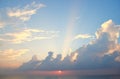 Bright Sunrays Coming through Clouds in Blue Sky with Golden Sun Setting over Ocean Royalty Free Stock Photo