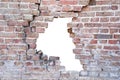 Photograph of a broken porous old brick wall with hole after accident