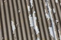 Photograph of brown paint peeling off a corrugated iron roof