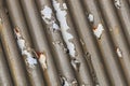 Photograph of brown paint peeling off a corrugated iron roof