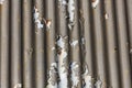 Photograph of brown paint peeling off a corrugated iron roof