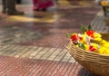 A photograph of a Cane basket filled with colorful flower for sell outside a temple in India. Royalty Free Stock Photo