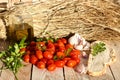 Photograph of Cherry tomatoes with garlic and bread on rustic background.