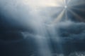 Photograph of a cloudy sky with lead clouds and dim light hitting the clouds, and the bright rays of the sun from the clouds with Royalty Free Stock Photo