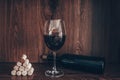 Photograph of corks and glass of red wine and bottle of wine all on wooden background Royalty Free Stock Photo