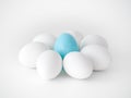 Photograph of a cute flower shape created from the arrangement of white chicken eggs as petals and a blue plastic Easter egg at