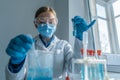 The photograph depicts a biologist conducting experiments on cells in a biotechnology laboratory to study biological