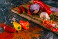 Assortment of peppers, garlic and onions on a stone countertop Royalty Free Stock Photo